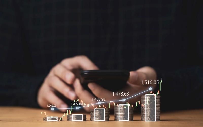 Stacks of coins with a rising growth chart